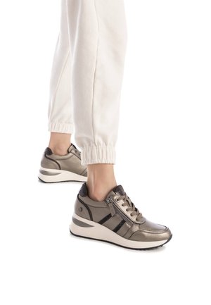 Zapatillas con un acabado marrón metálico, que cuentan con un cierre de cremallera, cordones y franjas negras en contraste, montadas sobre una suela blanca y acolchada.