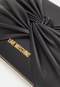 Clutch in pelle nera con un design annodato sul davanti, caratterizzato da un accento dorato con il logo "LOVE MOSCHINO" e una finitura in oro lucido.