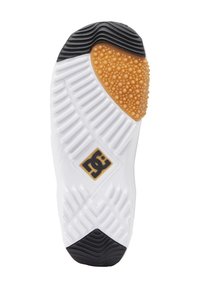 Suela blanca con acentos de goma negra y color caramelo, superficie texturizada, logo de estrella en negro y dorado, y múltiples patrones de banda de rodadura para mayor agarre.
