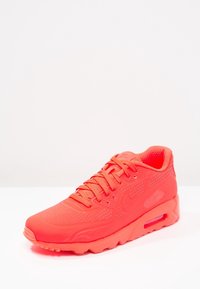 Nike Air Max-sneakers i klar röd färg. Har en strukturerad ovandel med perforeringar, snördesign och synlig luftkuddning i sulan.