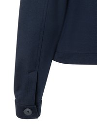 Marineblauwe jas mouw met een getailleerde pasvorm, met een knoopsluiting en een soepele stoftextuur. Netjes gestikte rand bij de manchette.