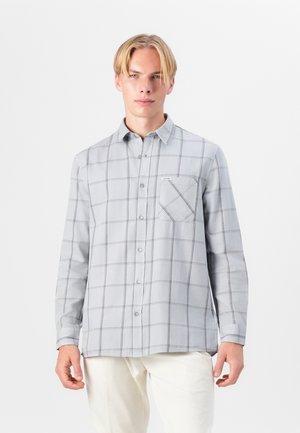 Camisa de botones gris claro con un patrón de cuadros, con un bolsillo en el pecho y mangas largas. Hecha de una tela suave, con costuras detalladas visibles.
