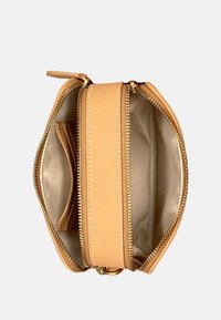 Piccola borsa in pelle color beige chiaro con finitura testurizzata, dotata di zip dorate e un interno beige con uno scomparto aggiuntivo per carte.