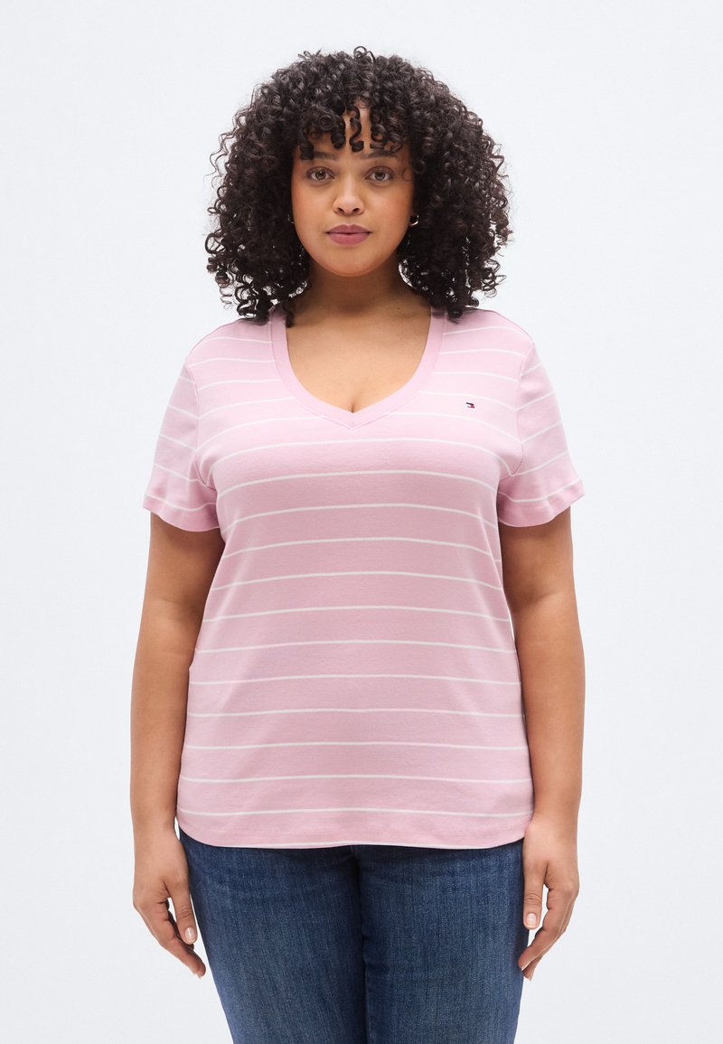 Ροζ ριγέ μπλουζάκι με V λαιμόκοψη και κοντά μανίκια, φτιαγμένο από απαλό ύφασμα. Διαθέτει λεπτές λευκές ρίγες και μικρό λογότυπο στο στήθος.