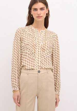 Blusa a maniche lunghe color crema con un motivo floreale in rosa e verde. Presenta una chiusura con bottoni sul davanti e dettagli arricciati lungo le spalle.
