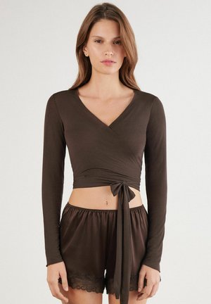 Braunes langärmliges Wickeloberteil mit Bindeband in der Taille, kombiniert mit passenden Shorts mit Spitzenbesatz. Weicher Stoff und figurbetontes Design.