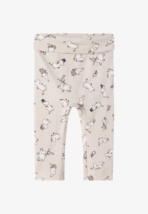Leggings beige con una cinturilla elástica que presentan un patrón repetido de personajes en estilo cartoon y varios accesorios en colores más oscuros.