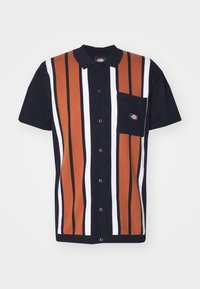 Chemise à manches courtes avec boutons, rayures verticales noires, blanches et rouille, col noir et poche poitrine noire avec un petit écusson logo.