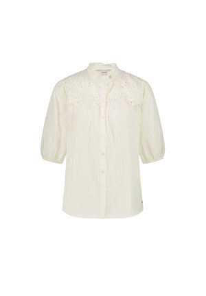Witte katoenen blouse met een volants hoge hals, broderie met oogjes op het schouderstuk en korte pofmouwen. Voorzien van een knoopsluiting aan de voorkant.