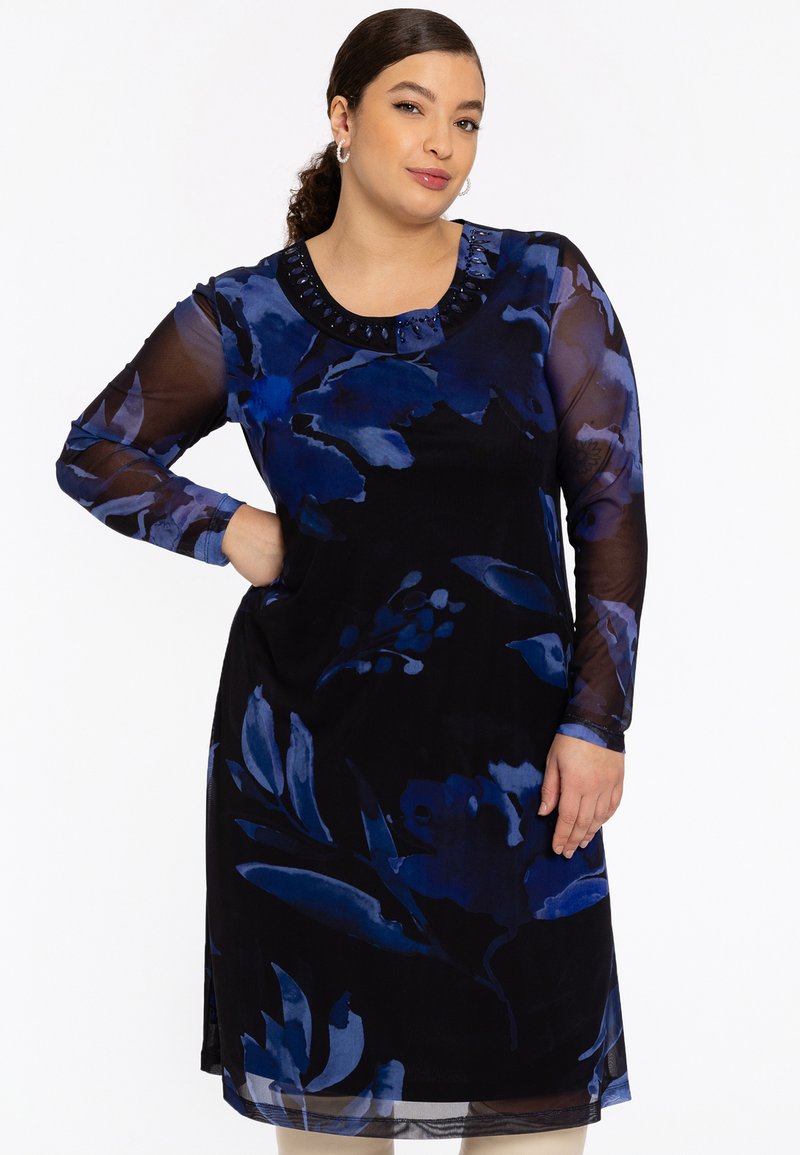 Langärmliges Kleid in Schwarz mit blauen Blumenmustern, mit einem runden Ausschnitt, der mit dekorativen Perlen verziert ist. Leichter, fließender Stoff.