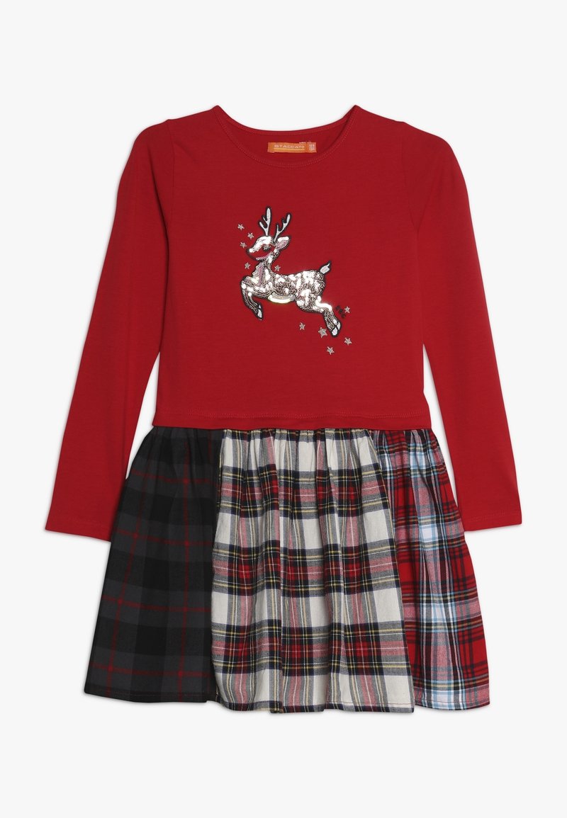 Robe rouge à manches longues avec un renne en sequins sur la poitrine et une jupe plissée présentant trois motifs à carreaux différents en noir, blanc et rouge.