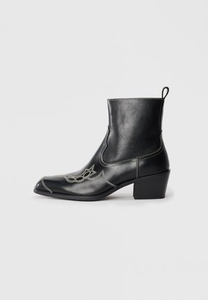Black leather ankle boots with a square toe, decorative stitching, and a low block heel. Features a pull tab for easy wear.