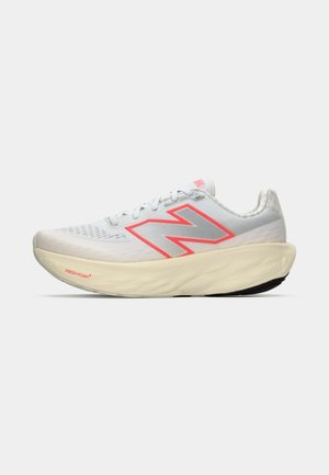 Witte hardloopschoen met een dikke beige zool, grijs en roze New Balance "N" logo, en de tekst "Fresh Foam" op de rand van de zool.