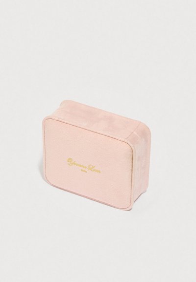 Mīksts rozā samta rotaslietu kaste ar noapaļotām malām un zelta iegravētu tekstu uz vāka baltā fonā.