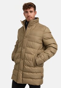 Khaki Steppjacke mit hohem Kragen, horizontalen Nähten, Vorderknöpfen und seitlichen Taschen, aus einem glatten, strapazierfähigen Stoff.