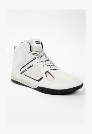 Scarpa sportiva alta in suede bianco e mesh, con accenti neri, punta arrotondata e suola in gomma testurizzata con battistrada a motivi.