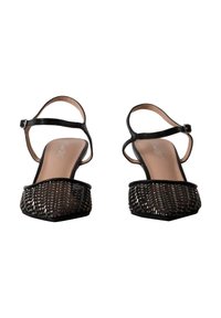 Ballerines slingback tissées noires à bout pointu avec brides à la cheville et petits talons, vues de face sur fond blanc.