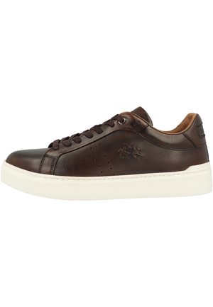 Dunkelbrauner Leder-Low-Top-Sneaker mit schwarzen Schnürsenkeln, geprägt seitlichem Logo und dicker weißer Gummisohle.