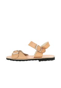 Tan leather sandal with adjustable straps and silver buckles; flat sole with a textured black outsole; open-toe design and minimalistic style.