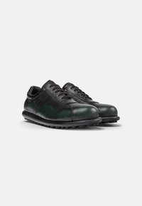 Scarpe in pelle verde e nera con punta arrotondata, design con lacci, pannelli laterali texturizzati e suola in gomma nera con piccoli dettagli a battistrada.