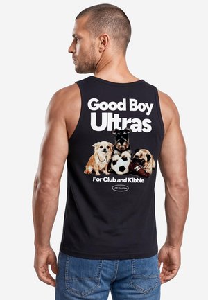 Mann trägt schwarzes ärmelloses Shirt mit drei Hunden und dem Text "Good Boy Ultras For Club and Kibble" auf dem Rücken.