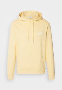 Hellgelber Kapuzenpullover mit frontaler Kängurutasche und weißem Schriftzug "LES DEUX COPENHAGEN EST. 2011" auf der Brust.