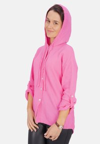 Rosa Kapuzenshirt aus strukturiertem Stoff, mit einem durchgehenden Knopfverschluss, umgeschlagenen Ärmeln und Kordeln an der Kapuze.