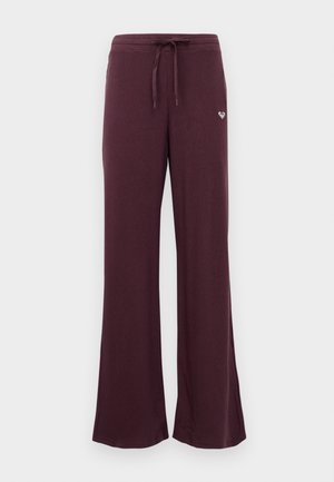 Paarse wijde broek van ribbelstof, met een tailleband met trekkoord en een klein hartlogo aan de voorkant. Zacht textuur en een losse pasvorm.