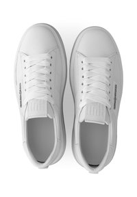 Witte sneakers met een glad synthetisch materiaal, ronde neus, zes rijggaatjes voor veters en een reliëflogo op de zijkant en tong.