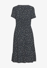 Vestido de estampado floral en azul marino con mangas cortas, cintura fruncida y falda acampanada. Presenta pequeñas flores blancas y azules en toda su superficie.