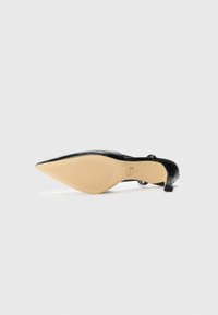 Schwarzer, spitz zulaufender Absatzschuh mit strukturierter Oberfläche, der über einen dezenten Absatz, eine nude-farbene Sohle und ein elegantes Design verfügt.