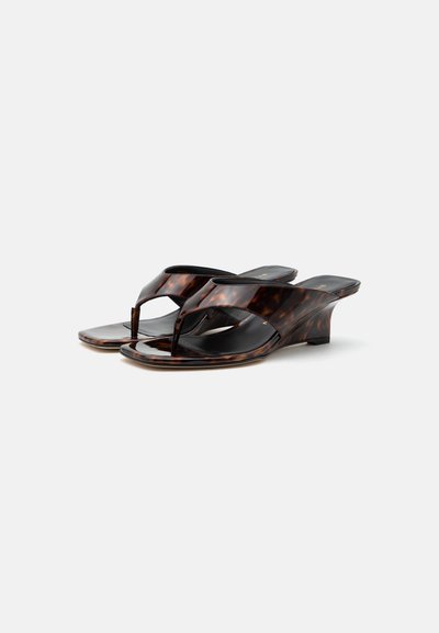 Sandales compensées marron écailles avec brides entre les orteils, bouts carrés et talons bas sur fond blanc.