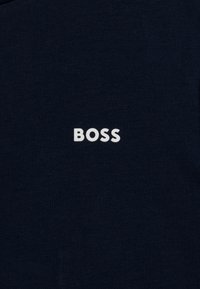 Námornícky modré bavlnené tričko s bielym logom "BOSS" umiestneným v strede hrudníka, s jemnou textúrou a klasickým crew neck strihom.
