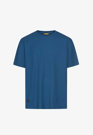 T-shirt bleu à manches courtes et col rond avec un petit logo sur la poitrine et une étiquette près de l'ourlet inférieur sur fond blanc.