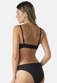 Ensemble de lingerie noire avec une finition métallique texturée, des bretelles réglables, une fermeture à crochets et œillets, et un design minimaliste pour le confort.