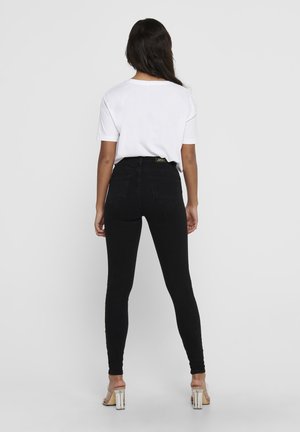 Black skinny jeans with a high waist, made of denim, featuring two back pockets, and a subtle brand tag at the waistband.