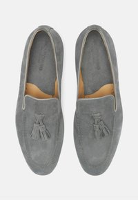 Grå ruskinds loafers med kvastdetalje, syede accenter og en glat indvendig foring. Slip-on design med en rund tåform.