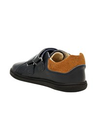 Sneaker blu navy per bambini con due cinturini in velcro e dettaglio in suede marrone sul tallone, mostrato di lato e dietro.