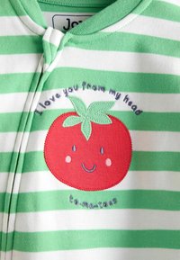 Tissu rayé vert et blanc avec une broderie de tomate rouge, représentant un visage souriant et le texte « Je t'aime de la tête aux to-ma-toes. »