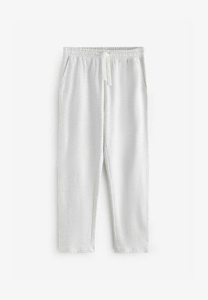 Valged, pehmed puuvillased loungesärgid, millel on elastne vöökoht ja nööred, kahes külgses taskus ning lõdvendatud lõige.