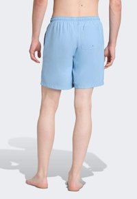 Světle modré plavky vyrobené z lehkého materiálu. Mají elastický pas a zadní kapsu, s volným střihem.