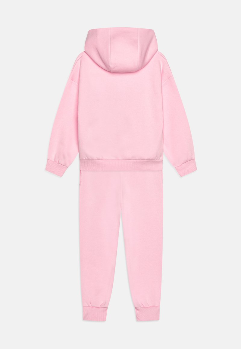 Tuta rosa composta da una giacca con cappuccio e pantaloni coordinati. Realizzata in tessuto morbido con polsini e vita a coste per una vestibilità aderente.