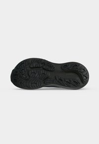 Black Brooks running shoe sole with textured tread pattern for grip and the Brooks logo in the center.