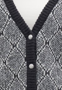 Cardigan grigio e bianco con motivo a fantasia, scollo a V, tessuto lavorato a maglia testurizzato e tre bottoni decorativi in tinta argento sul davanti.