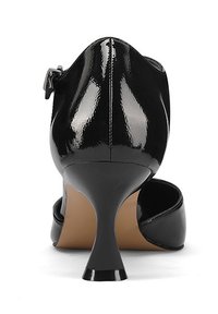 Scarpa con tacco alto in vernice nera, caratterizzata da un tacco curvo e sottile e da un design con apertura posteriore. Presenta una cinghia regolabile alla caviglia per una vestibilità sicura.