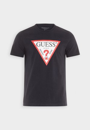 Zwarte katoenen T-shirt met een grote rood-witte driehoekige grafiek met de tekst "GUESS® U.S.A. WASHED JEANS" en een vraagteken.
