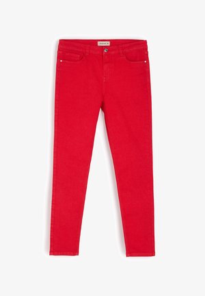Czerwone dżinsy o slim fit. Z pięcioma kieszeniami, z przodu zapinane na guzik oraz dyskretnymi detalami przeszyci wzdłuż szwów.