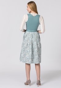 Blaue und weiße gemusterte Dress mit einem taillierten Oberteil und plissiertem Rock. Verfügt über eine glatte Textur und ein V-förmiges Rückendesign. Graue Absätze.