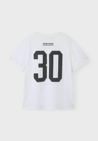 Balts kokvilnas T-krekls ar melniem svītrainiem "30" dizainu un sportiskā stilā rakstītu "NEWYORK" tekstu augšpusē. Parastā piegrieztne ar īsām piedurknēm.