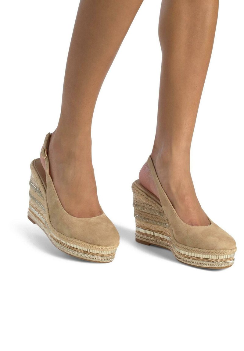 Beige suède wedge schoenen met een slingback ontwerp. Kenmerken zijn textuurstro van stro en metallic accenten op een gelaagde hak.